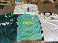 Four soccer jerseys laid flat showing fronts, colours and logos