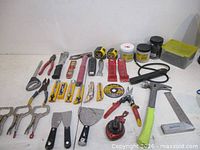 Complete layout of hand tools, clamps, knives, hammer, level, chalk reel and tubs of screws