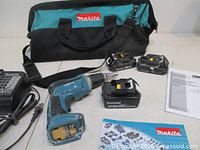 Complete set showing screwdriver, three batteries, charger, bag, manuals