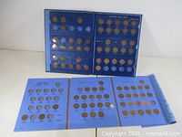 Both open folders showing filled coin slots