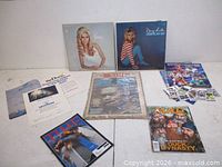 Group shot of all items including two Nancy Sinatra LPs, newspapers, magazines, certificate and trading cards