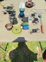 Tabletop view showing majority of glass, metal and ceramic candle holders plus rug beater