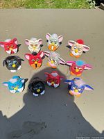 Group shot of 12 Furby figures outdoors