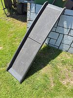 Ramp fully extended against low wall showing walking surface and rails