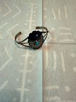 Top view of sterling cuff showing flower concho and turquoise stone