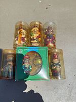 Six mercury glass teddy bear ornaments in individual clear tubes with one green box containing two ornaments