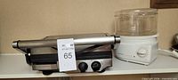 Front view of Breville panini press closed beside Black & Decker steamer