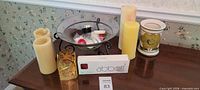 Overall view showing pillar candles, votive holder, glass bowl on stand, tealights, boxed Abbott candle, ceramic vase