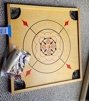 Full view of wooden Carrom board with bag of pieces