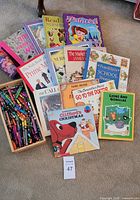 Overview of all books and crayon tray on carpet