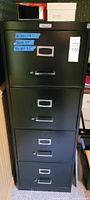 Front view of black 4-drawer file cabinet showing handles, label frames and overall exterior