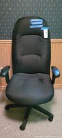 Full view of black high-back fabric office chair on casters