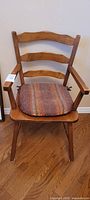 Front view of maple ladder-back armchair with cushion