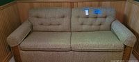 front view of tweed sofa bed showing overall condition and missing buttons
