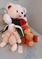 Group shot of all three stuffed animals on bed