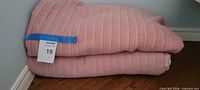 Folded pink ribbed blanket, overall view