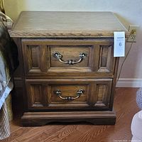 Front view of one oak end table showing drawers and hardware
