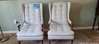 Both wingback chairs side by side showing overall design and wood legs