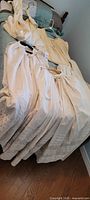 Overview of five off-white cotton garments on bed