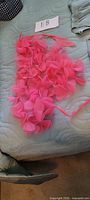 Pink petal-embellished scarf laid flat on bed