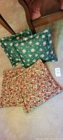 Two floral pillows and two holiday covers displayed together