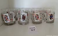 Eight clear glass tumblers with playing card designs