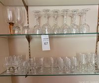 Shelved assortment of wine, goblet and cordial glasses