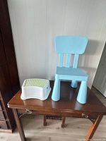 Blue IKEA children’s chair and white step stool on table