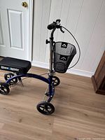 Overall view of blue and black KneeRover knee scooter showing frame, wheels, seat, handlebar and basket