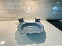 Bowl and two mugs front view on countertop