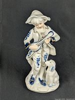 Full view of figurine showing musician, dog, and base
