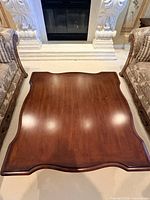 Top view of square serpentine-edge coffee table between sofas