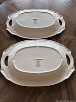 Underside of both platters showing brand mark, glaze, and overall condition
