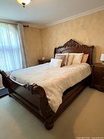 Full view of queen sleigh bed assembled with carved headboard and footboard