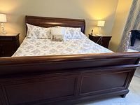 Front view of assembled dark cherry king sleigh bed with mattress
