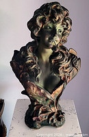 Front view of painted chalkware Art Nouveau female bust showing hair, face, and floral base