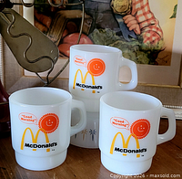 Front view of three McDonald's Fire-King Good Morning milk glass mugs