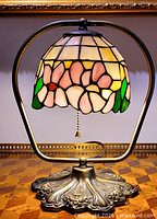 Lamp showing stained glass shade, metal frame, ornate base