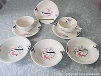 Full set: four bowls, two cups on saucers, one saucer displayed upright