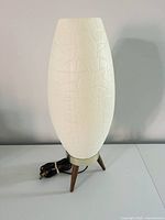 Full view of the table lamp showing body, legs, cord