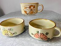 Front view of all three handled soup bowls showing motifs and sizes