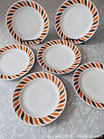 All six swirl-pattern plates arranged on table