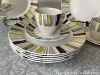 Stack of plates with cup and saucer on top displaying Mandalay pattern