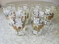 Six patterned highball glasses arranged on textured surface