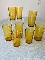 Front view showing all eight amber optic swirl glasses