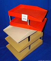 Three tan/light ochre trays stacked with two orange trays stacked on top showing overall lot