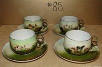 Four cup and saucer sets displayed