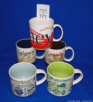 Front view of five Starbucks location mugs showing designs and interiors