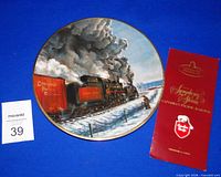 Front of collector plate with locomotive artwork, brochure visible