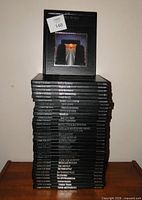 Full stack of 33 black hardcovers, spine titles visible